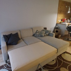 Patogi ištiestinė sofa su trimis pagalvėmis ir stalčiumi